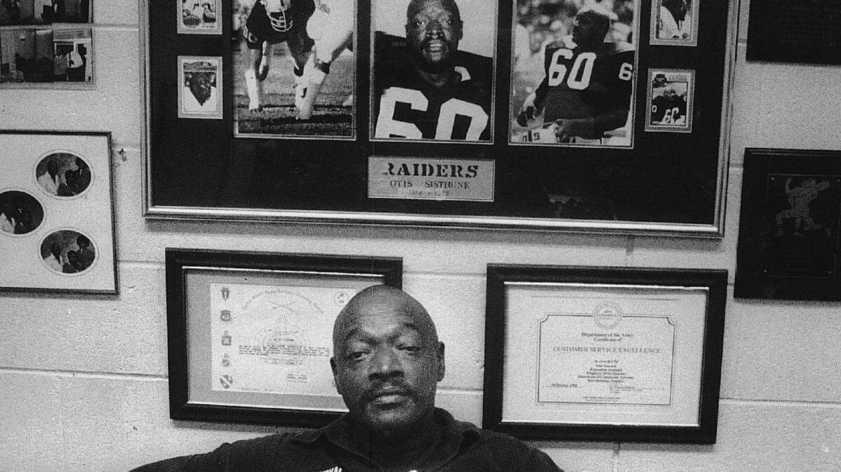 Otis Sistrunk sits in front of memorabilia from his playing career.
