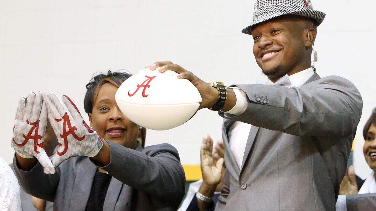 Gordo High School football player Ben Davis, with his mother Faye, left, holds up a football after committing to attend Alabama during a national signing day Program at Gordo High School, Wednesday, Feb. 3, 2016, in Tuscaloosa Ala. (Michelle Lepianka Carter/The Tuscaloosa News via AP) NO SALES; MANDATORY CREDIT