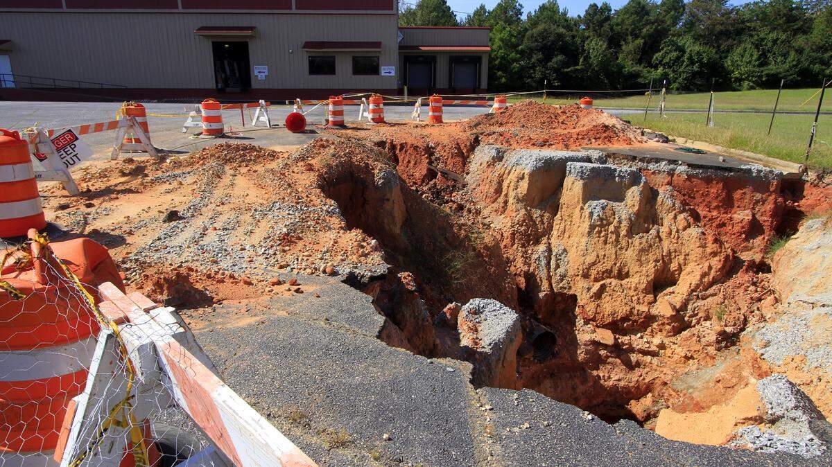 A large sinkhole that occupies a corner of the parking lot at Tate Furniture in Phenix City in shown in this file photo from Oct. 7, 2014.