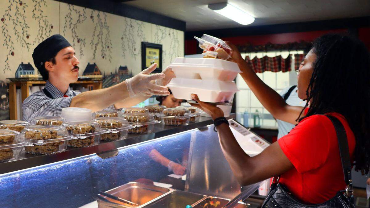 Krystian Larson hands a lunch buffet special to a customer. 7/15/24