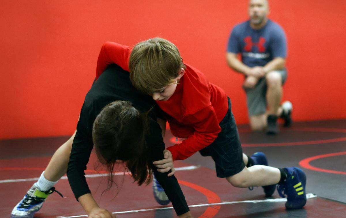 Landon Paris, center, wrestles as his father Carson watches during a recent practice for the Bison Takedown youth wrestling team in Columbus, Georgia 03/21/2024