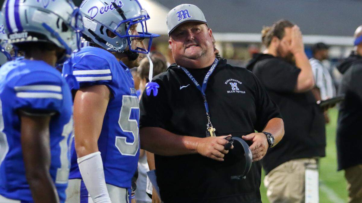 Manchester High School head football coach Stephen Holmes talks to a player on the sideline during the Sept. 8, 2023, game against Lamar County on Greg Oglesby Field at Manchester Memorial Stadium.