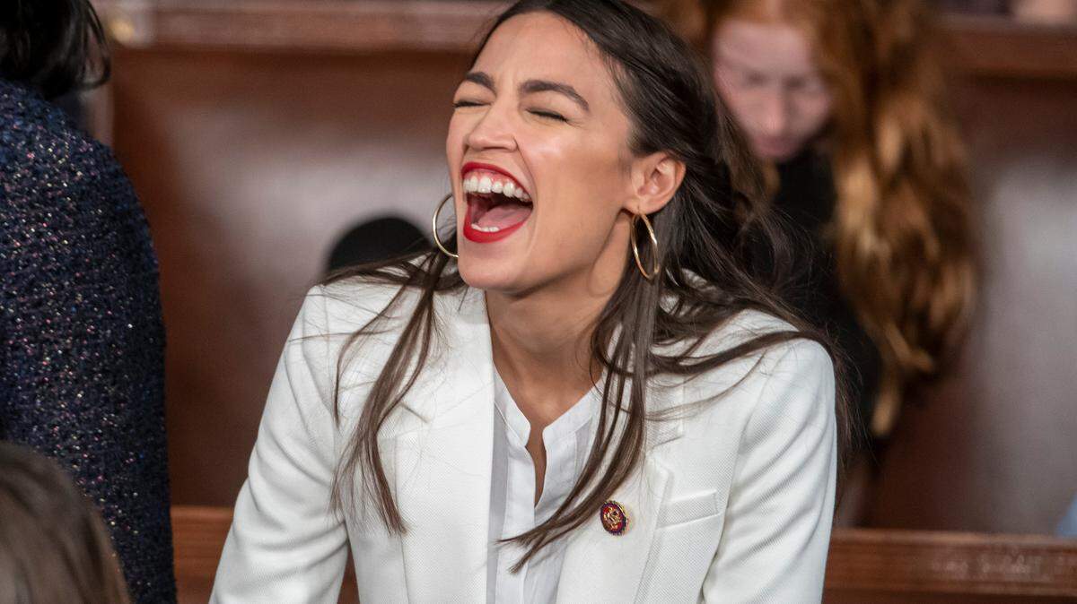 Rep. Alexandria Ocasio-Cortez, D-N.Y., laughs out loud as she talks with other new House members on the opening day of the 116th Congress, at the Capitol in Washington, D.C., on Thursday.