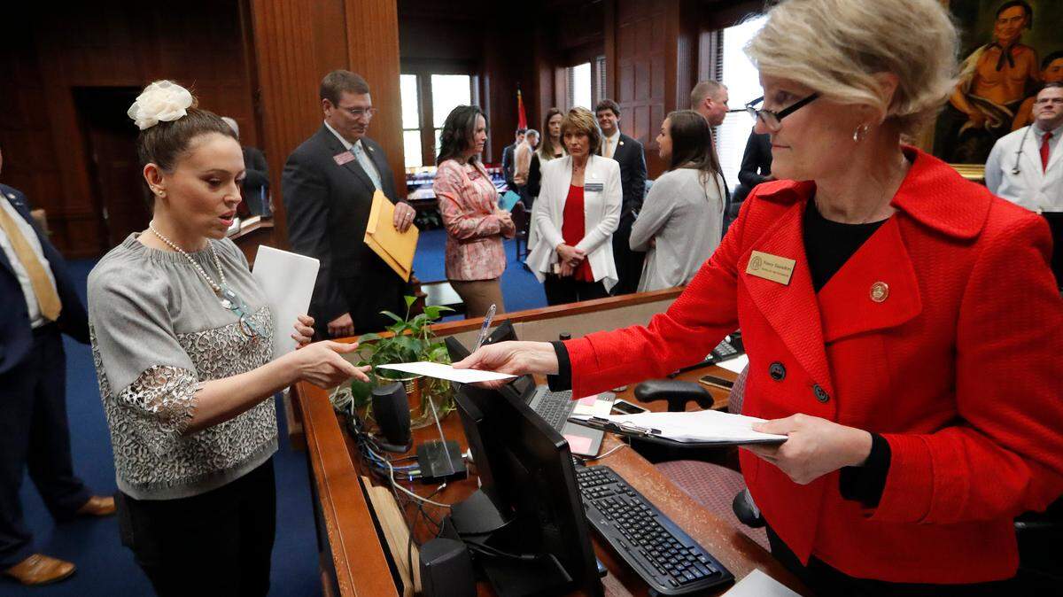Actress Alyssa Milano, left, delivers a letter to Georgia Gov. Brian Kemp’s office detailing her opposition to HB 481 at the State Capitol in Atlanta on Tuesday. HB 481 would ban almost all abortions after a fetal heartbeat can be detected.