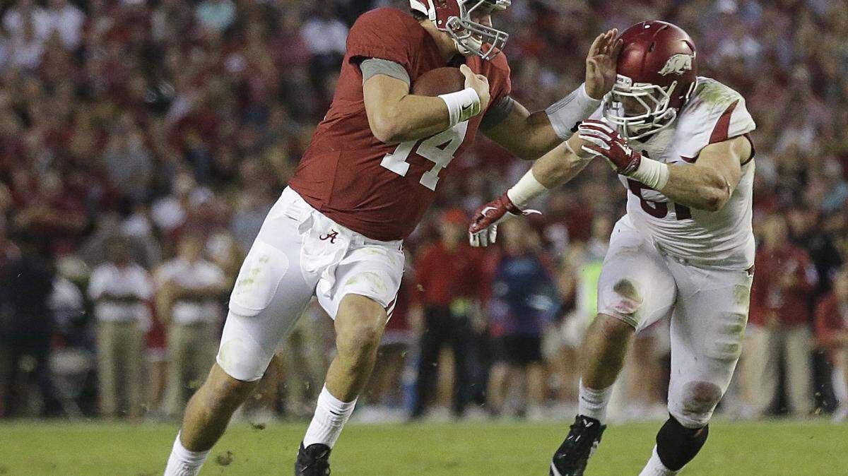 Alabama quarterback Jake Coker (14) runs the ball against Arkansas linebacker Brooks Ellis (51) in the first half of an NCAA college football game, Saturday, Oct. 10, 2015, in Tuscaloosa, Ala. (AP Photo/Brynn Anderson)