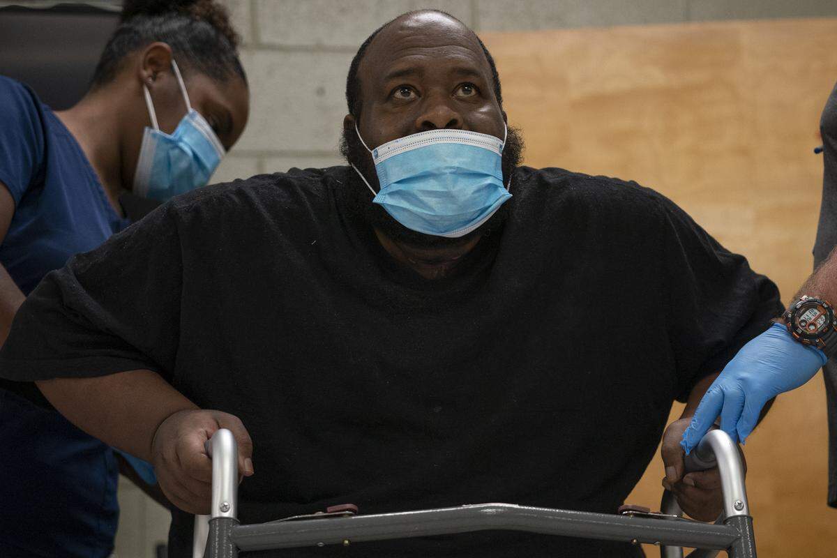 Using the support of a walker, Eric Lofton stands during physical therapy at River Towne Center nursing facility, on May 26, 2021, in Columbus, Ga.