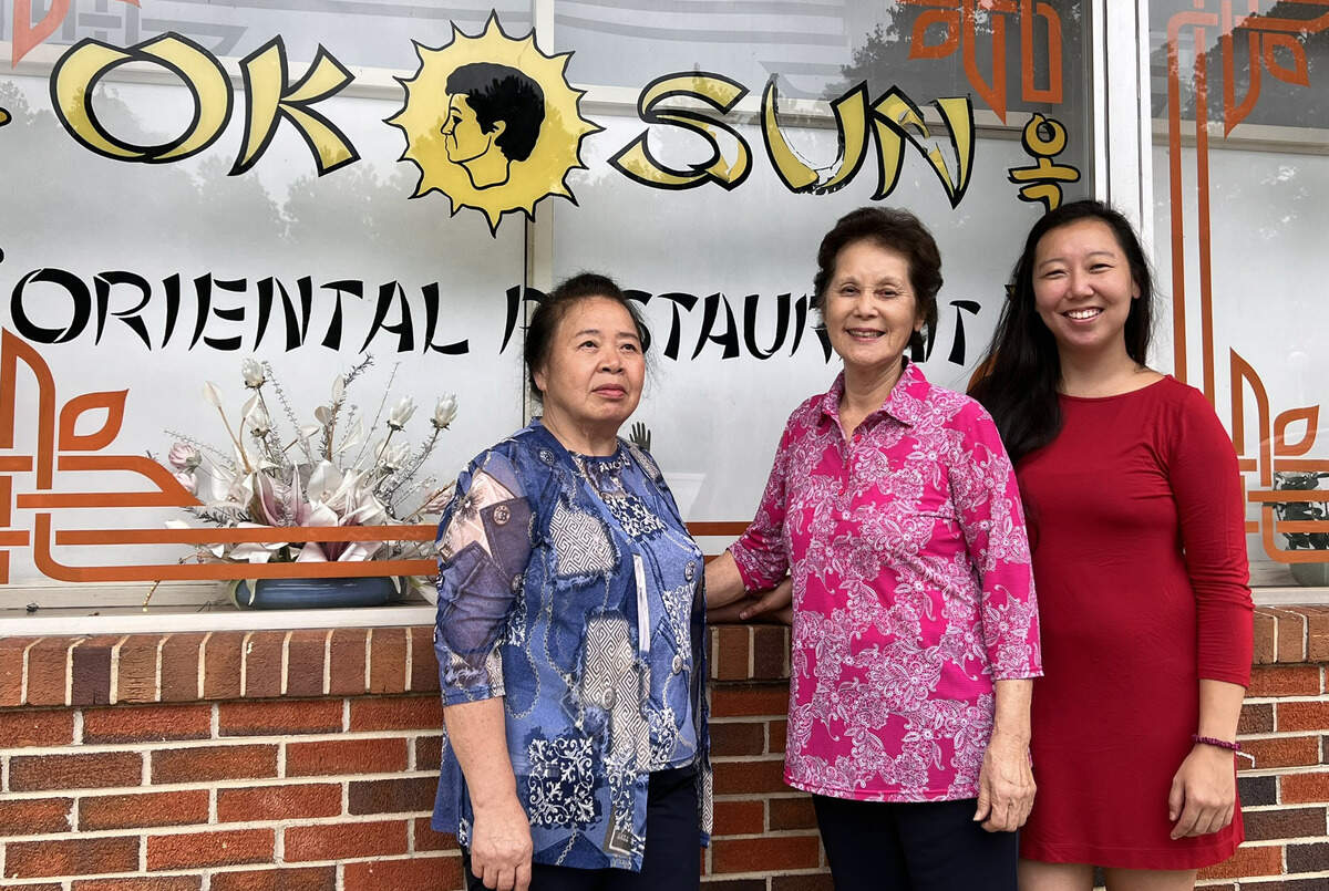 From left, Victoria Chong, Ok Sun Ferrell, and Victoria Chong pose for a photo outside Ok Sun Oriental Restaurant in Columbus, Georgia. Ok Sun Oriental Restaurant will open to serve loyal customers in Columbus for one final week as it prepares to permanently this year.