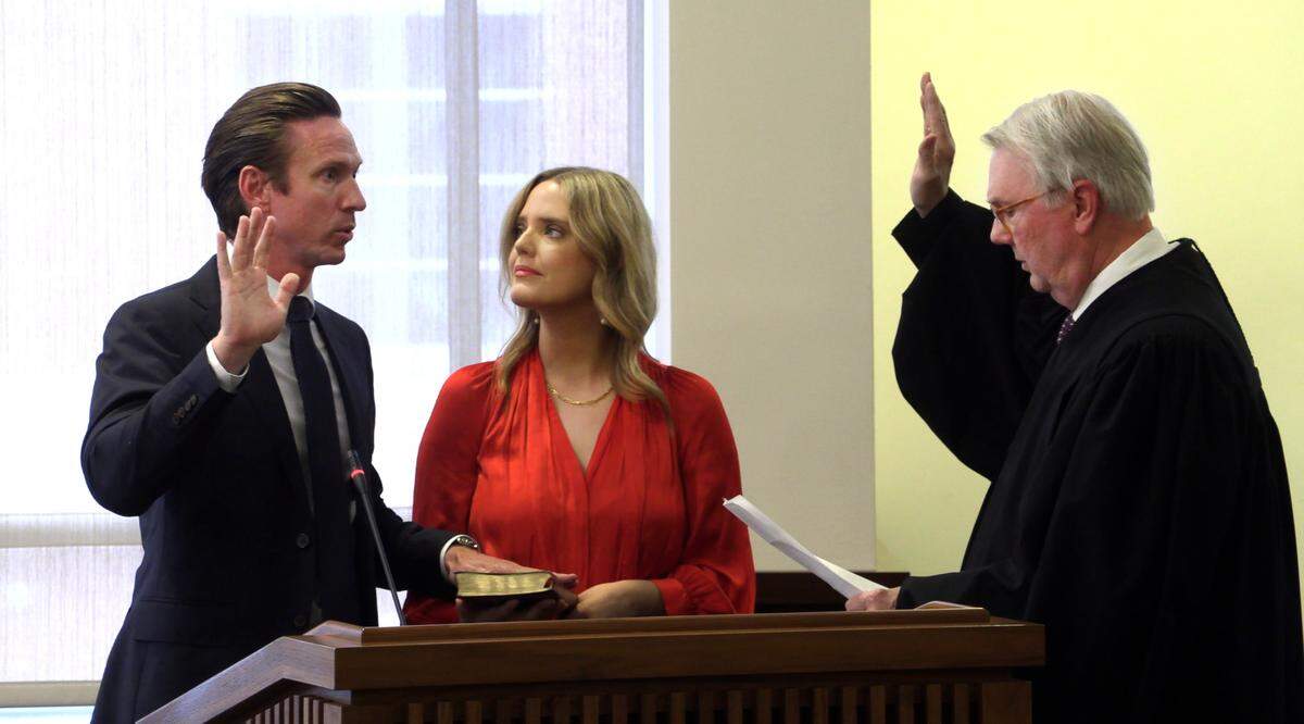Superior Court Judge Arthur Smith III, right, swears in Tyson Begly as a Columbus City councilor April 25, 2023, in Columbus, Georgia as Begly’s wife Rebekah holds the Bible.