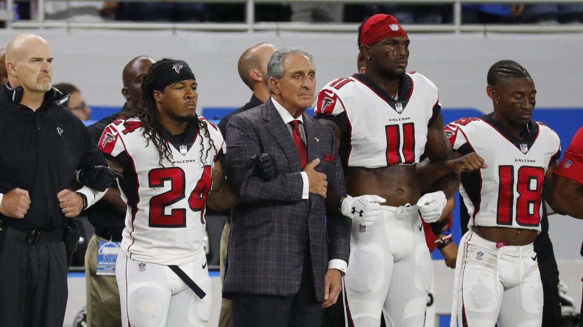 Atlanta Falcons owner Arthur Blank stands with his players during the national anthem before an NFL football game against the Detroit Lions, Sunday, Sept. 24, 2017, in Detroit.