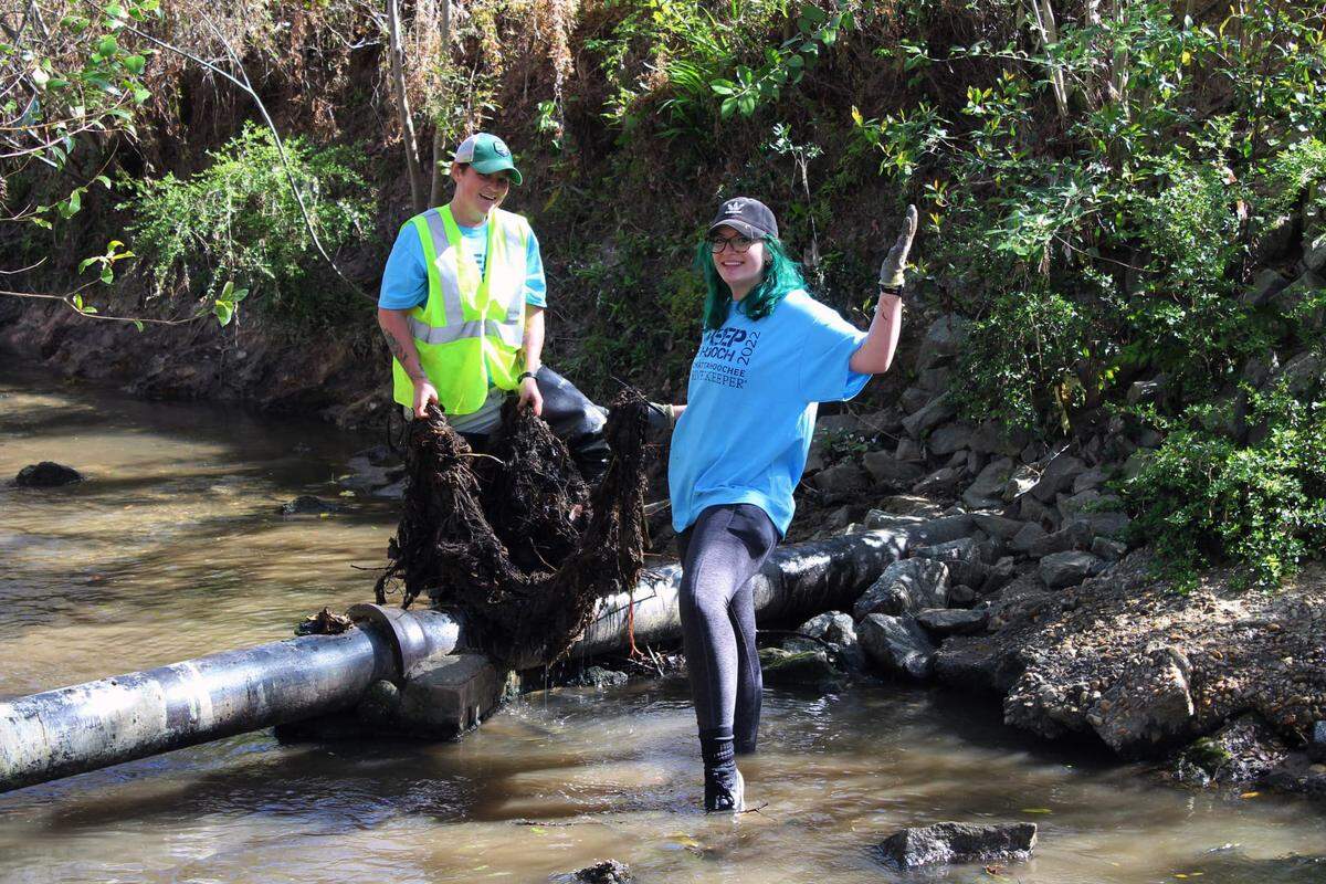 Glennis Desensi and Ashley Desensi clean up the Columbus tributary, Weracoba Creek, during “Sweep the Hooch” in 2022.
