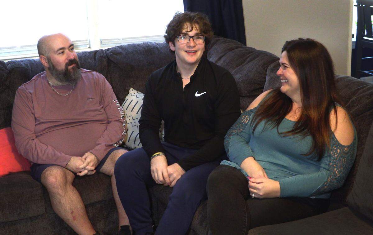 Rene Rodriguez IV, a 16-year-old junior at Rainey-McCullers School of the Arts, center, and his parents Rene Rodriguez, left, and Lindsay Woodson, answer questions during a recent interview. 02/06/2023