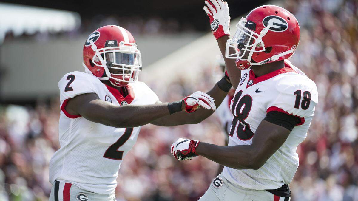 Georgia defensive back Deandre Baker (18) and Richard LeCounte (2) celebrate a defensive play against South Carolina during the first half of their game Saturday in Columbia, S.C.