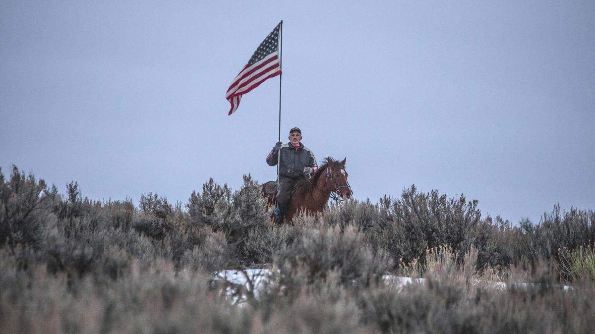 An armed man going by his first name only, Dwayne, rides near the entrance to the Malheur National Wildlife Refuge on Thursday, Jan. 7, 2016.