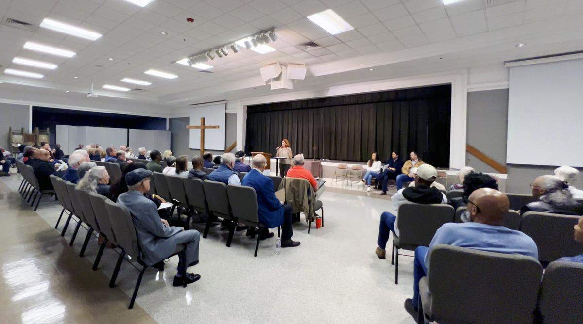 Karen Gaskins, at podium, a resident of the Sears Woods neighborhood in Columbus, Georgia, center, speaks during a recent meeting about a development proposed by Proterra Development that would require the rezoning of 115.56 acres of land at 5201 Macon Road in Columbus.