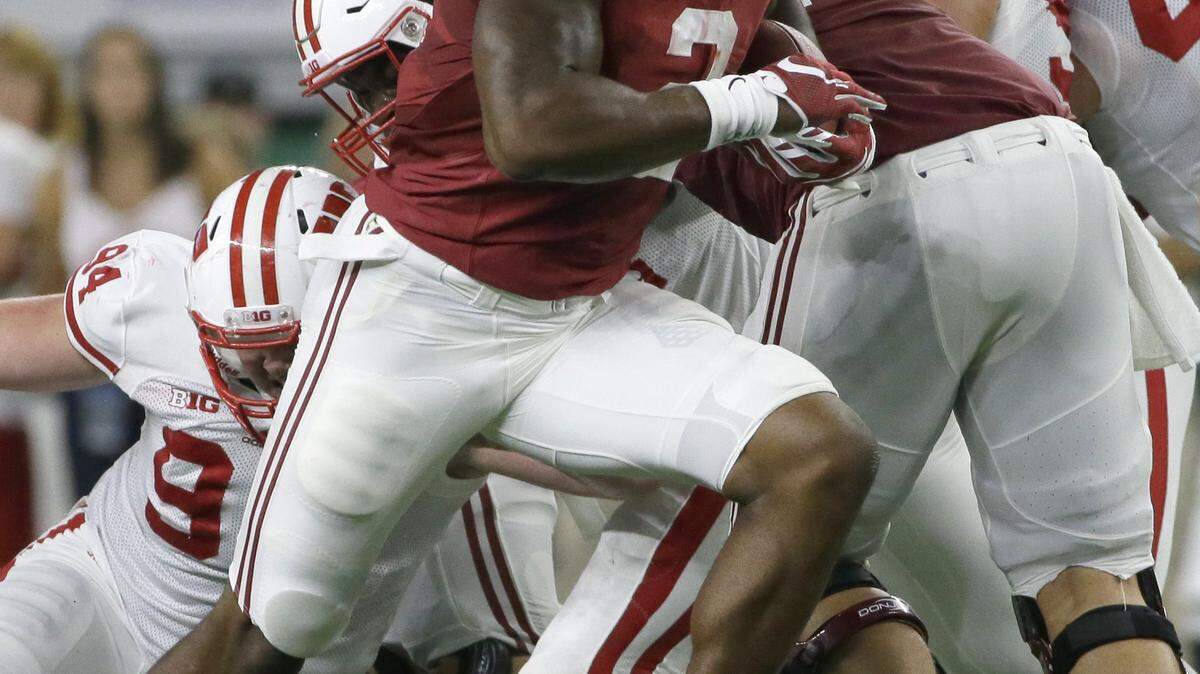 Alabama running back Derrick Henry (2) breaks tackles against Wisconsin defender Conor Sheehy (94), Arthur Goldberg (95) and others on his way to rushing for a touchdown during the first half of an NCAA college football game Saturday, Sept. 5, 2015, in Arlington, Texas. (AP Photo/LM Otero)