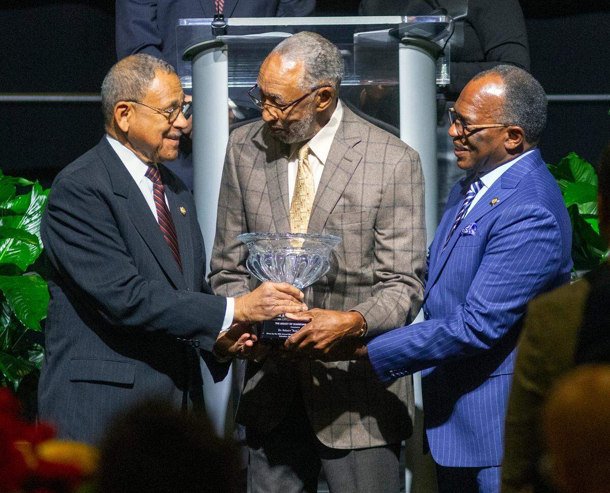 Dr. Robert “Bob” Wright, center, receives The Legacy of Leadership Award from U.S. Rep Sanford D. Bishop (D-Columbus), left, and Oz Roberts, right, on Monday morning at the 40th Annual Black History Month Observance Committee Breakfast at the Columbus, Georgia Convention & Trade Center. 02/17/2025