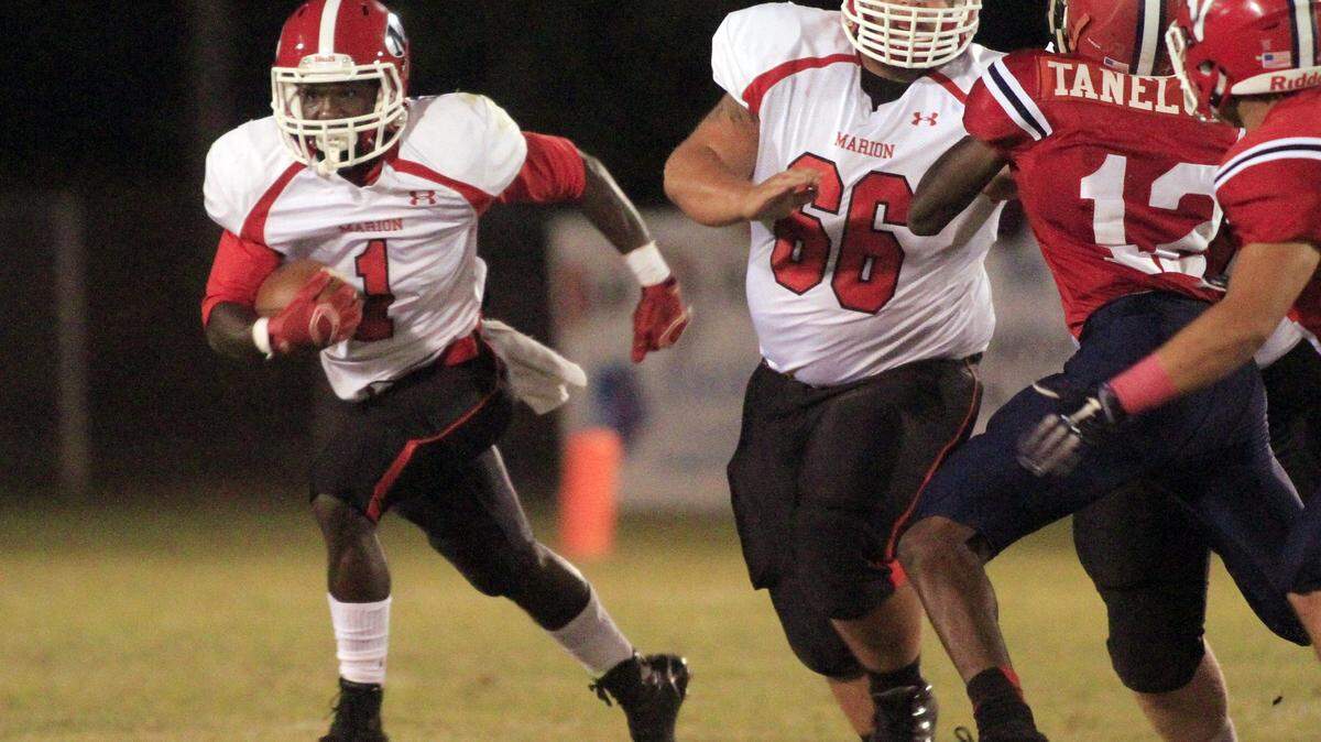 ROBIN TRIMARCHI/rtrimarchi@ledger-enquirer.comMarion County wide receiver Lorenzo Smothers carries the ball behind the blocking of nose guard Lonnie Taylor against Pacelli during first half play at Pacelli Oct. 2.