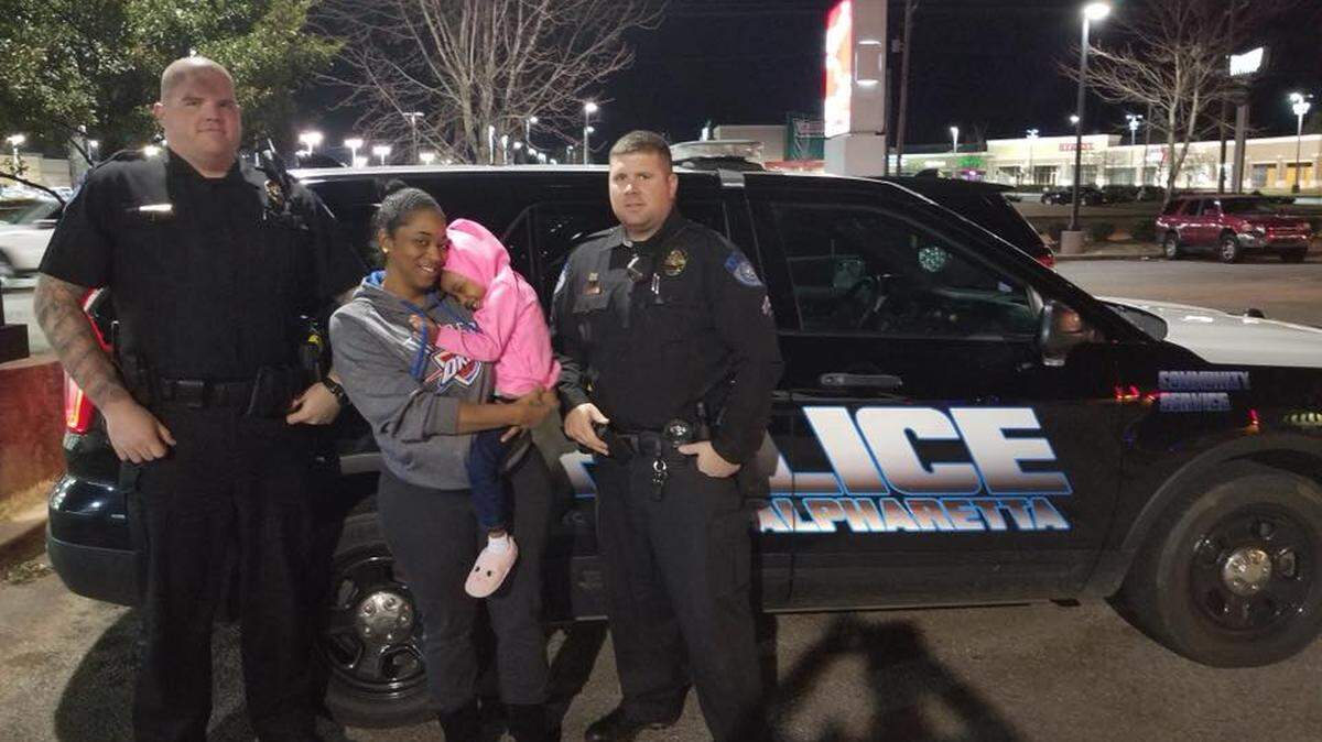 The girl, reunited with her mother alongside police.