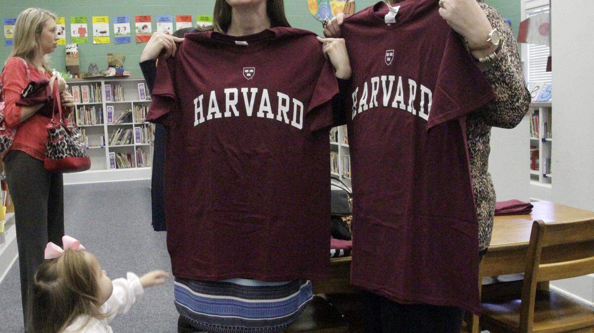 ROBIN TRIMARCHI rtrimarchi@ledger-enquirer.com 
 Ellie Reynolds, 2, reaches for her mother Amanda Reynolds, left, as she and Aaron Cohn Middle School colleague Stephanie Fuerte stand for a photograph after being named a Harvard Fellow, one of 11 Muscogee County School District teachers to receive the fellowhsip from the Muscogee Educational Excellence Foundation. The teachers will spend one week this summer studying and networking with top professionals in education. The announcement was made Thursday at the Wynnton Arts Academy. 02.18.16