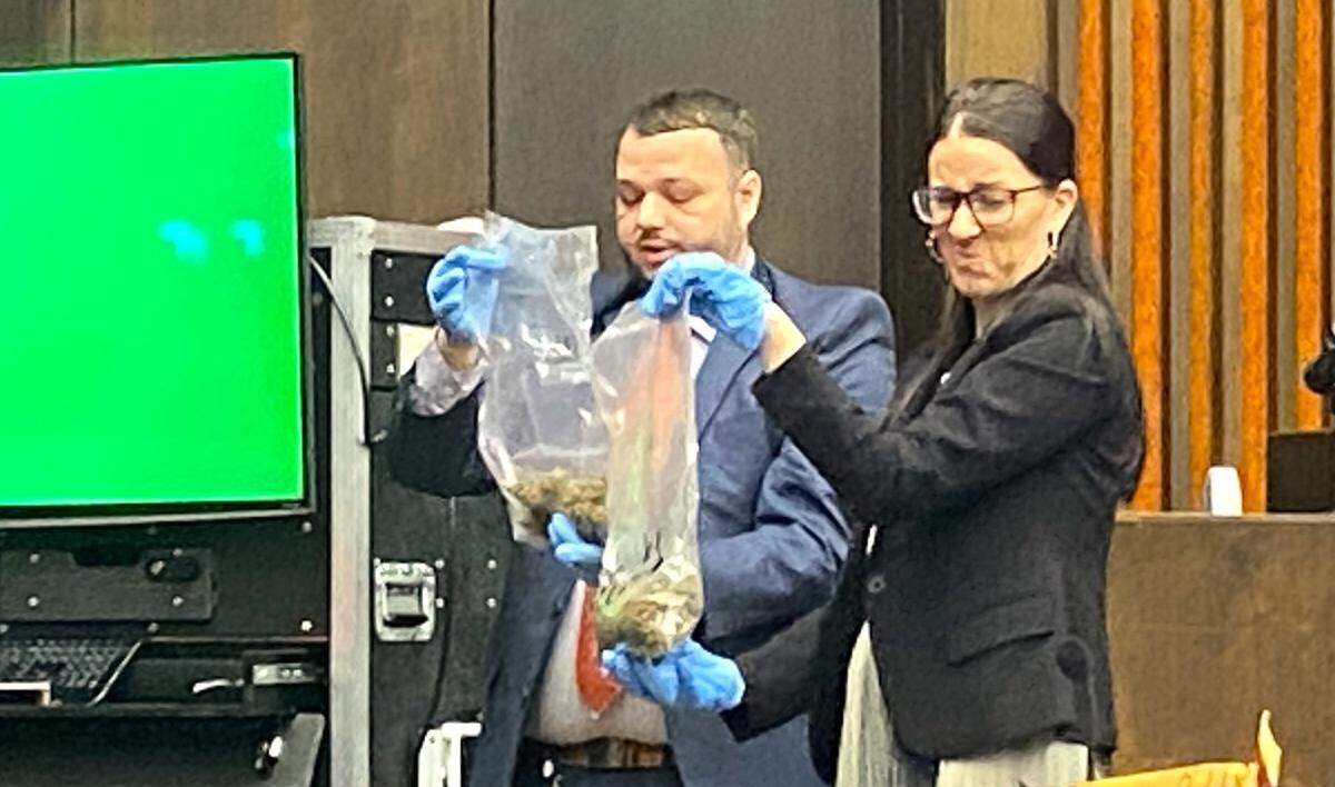 Prosecutor Cara Convery winces at the strong odor of marijuana as she and Columbus Police Sgt. Kyle Tuggle show jurors bags of it confiscated during the allegedly gang-related murder investigation.