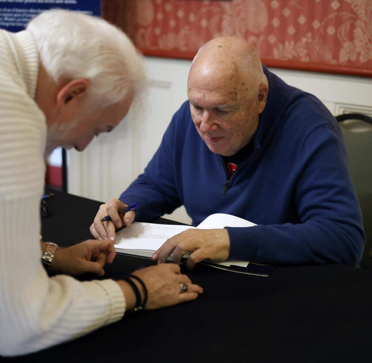 Paul Pierce, retired producing artistic director at the Springer Opera House in Columbus, signs a copy of the just-released second edition of “The Springer Ghost Book” on Dec. 19, 2025.