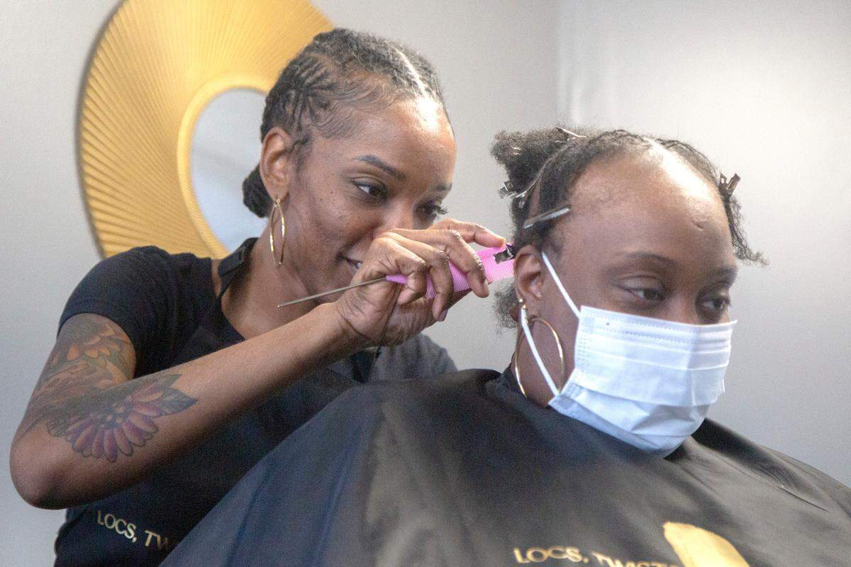 Owner Taniesa Taylor styles microlocs on a client at Locs, Twists, Braids and Crochets on Feb. 10, 2021, in Columbus, Ga.