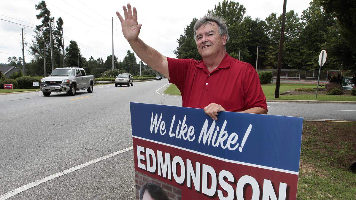 Muscogee County School Board candidate Mike Edmondson waves to passersby along River Road as voters go to the polls in 2018.