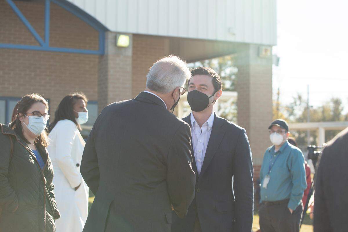 Columbus Mayor Skip Henderson and Senator Jon Ossoff shake hands on Nov. 23, 2021, at the METRA Transit System in Columbus, Ga. Ossoff and other Georgia Democrats are traveling through the state to recognize the bipartisan infrastructure deal passed last week.