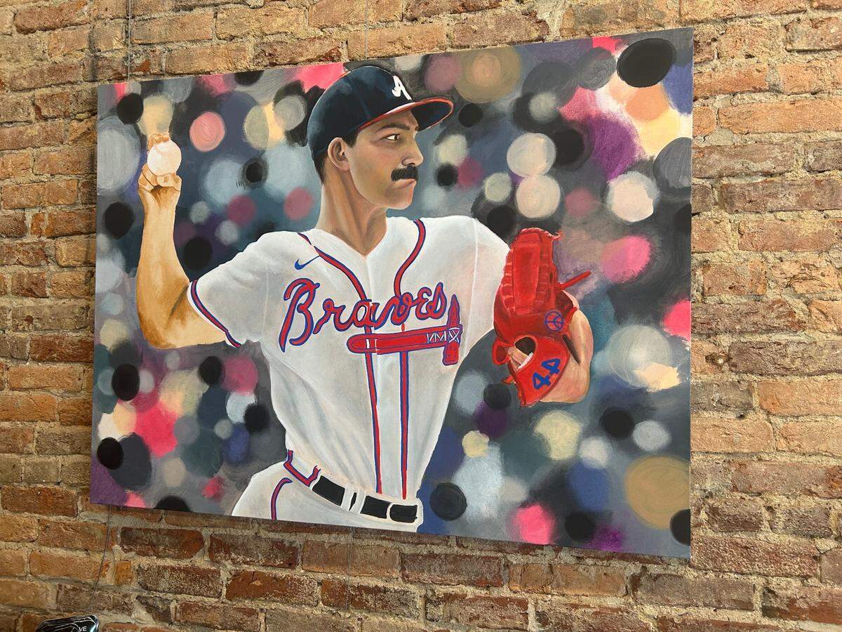 One piece of art by Cody Davis at C Davis Tattoo Studio on Broadway shows Atlanta Braves pitcher Spencer Strider throwing a pitch with a blurred crowd in the background.