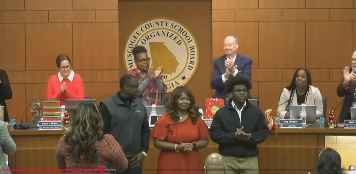 During its Dec. 15, 2025, meeting, the Muscogee County School District Board gives a standing ovation to (from left) Kendrick High School principal Alonzo James, Kendrick audio/video technology and film teacher Nicole Jones-Harper, and Kendrick junior Ta’Karious “TK” Lovejoy as they are honored for Kendrick’s third-place award in the 2025 Georgia School Boards Association Student Video Contest.