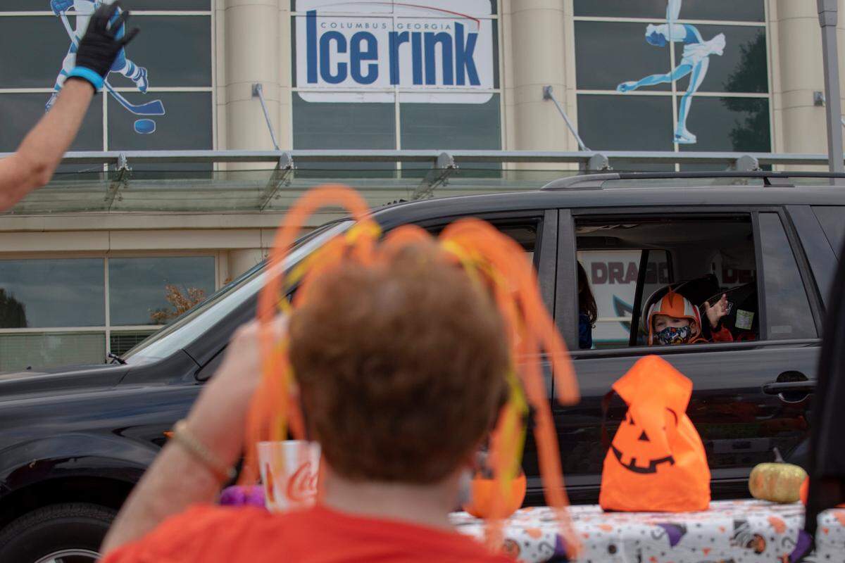 A young boy waves to volunteers at the Spooktacular Trunk or Treat event on Sunday, Oct. 25, 2020 at the Civic Center in Columbus.