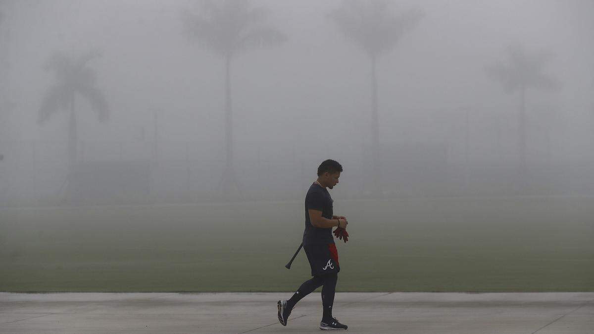 Atlanta Braves catcher William Contreras leaves the batting cages in the early morning fog at spring training baseball camp in North Port, Fla., Friday, Feb. 14, 2020. (Curtis Compton/Atlanta Journal-Constitution via AP)
