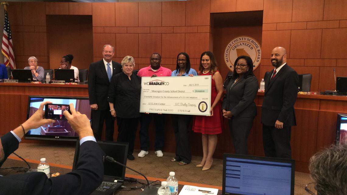 During the Muscogee County School Board's monthly work session July 9, 2018, W.C. Bradley Company vice president for stakeholder relations Susan Wiggins, second from left, presents a symbolic check for an undisclosed amount to represent the donation the company made to equip the STEAM Center the school district is creating at the former Muscogee Elementary School.