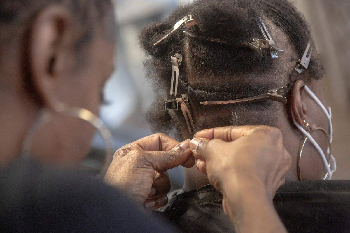 Owner Taniesa Taylor twists a microloc at Locs, Twists, Braids and Crochets on Feb. 10, 2021, in Columbus, Ga.