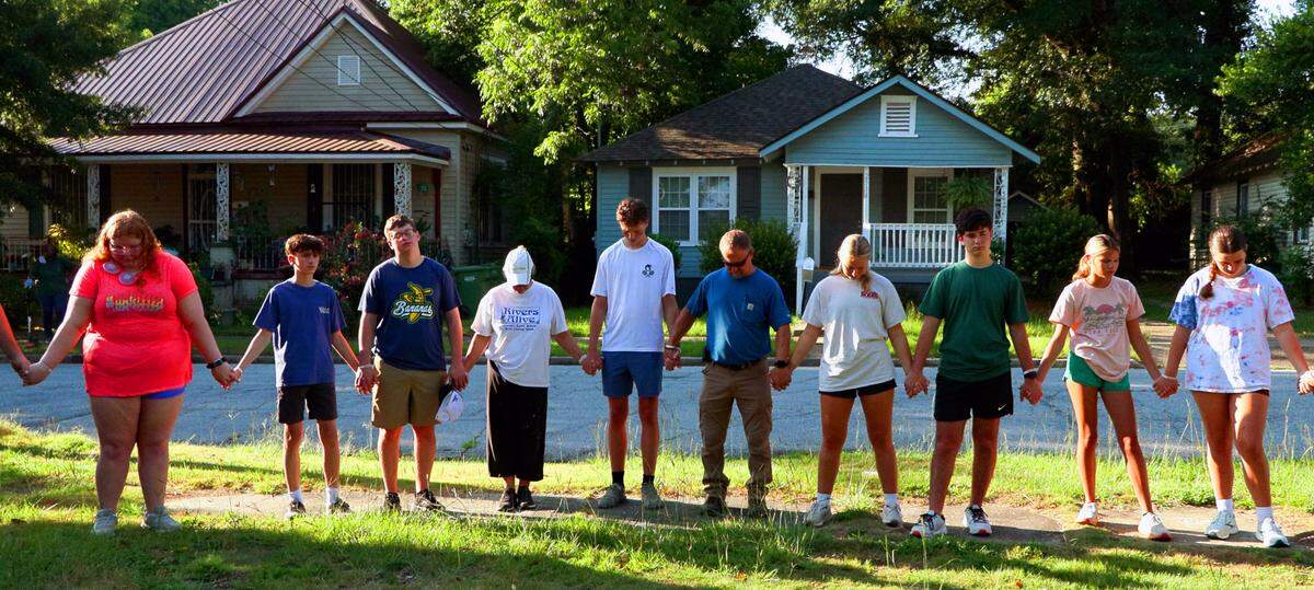 Participants in the River of Life mission project join hands in prayer July 10, 2025, before leaving Wynnton Methodist Church in Columbus to begin their first work day during the five-day mission project.