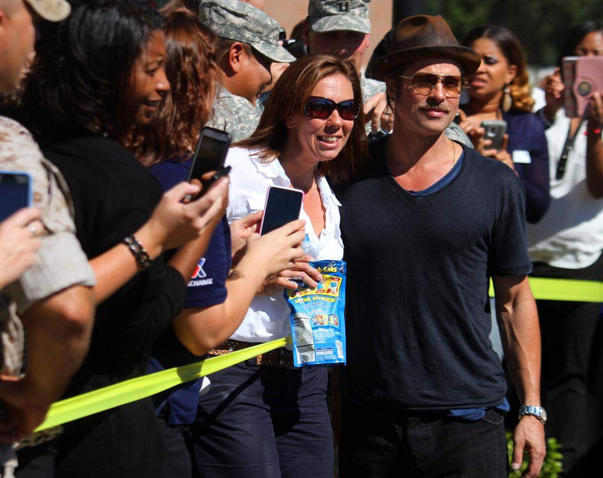 Actor Brad Pitt poses with Oneida Zacherl and other dans while visiting soldiers at Fort Benning and screening his new World War II tanker film ‘Fury’. 10.16.2013