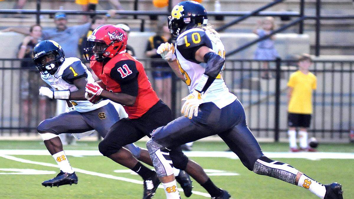 Central's Jamaar Spivey races between two Harris County defenders for a carry down to the 15 yard line in the first quarter of the game Friday night at Garrett-Harrison Stadium