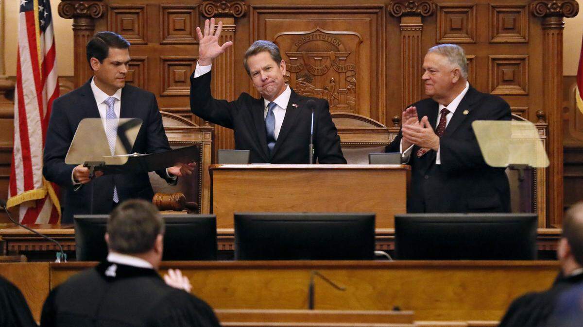 Georgia Gov. Brian Kemp, center, flanked by Lt. Gov. Geoff Duncan, left, and House Speaker David Ralston, receives applause after he delivered his first State of the State address, Thursday, Jan. 17, 2019, in Atlanta. (Bob Andres/Atlanta Journal-Constitution via AP)