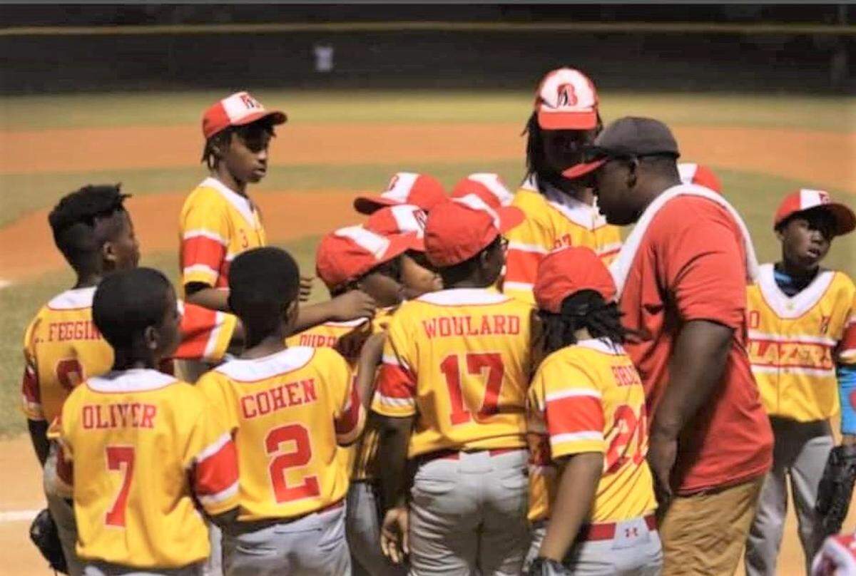 Chris Smith, president of the Sally Little League based at Shirley Winston Park, talks to players.