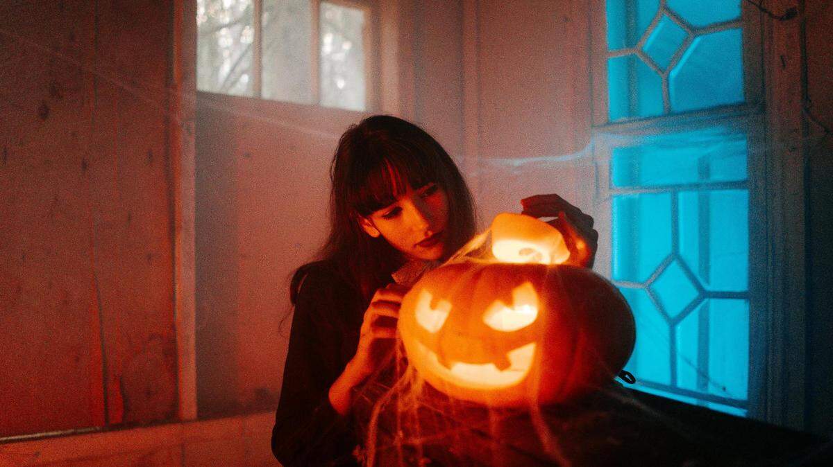https://www.pexels.com/photo/woman-with-a-carved-pumpkin-5435192/