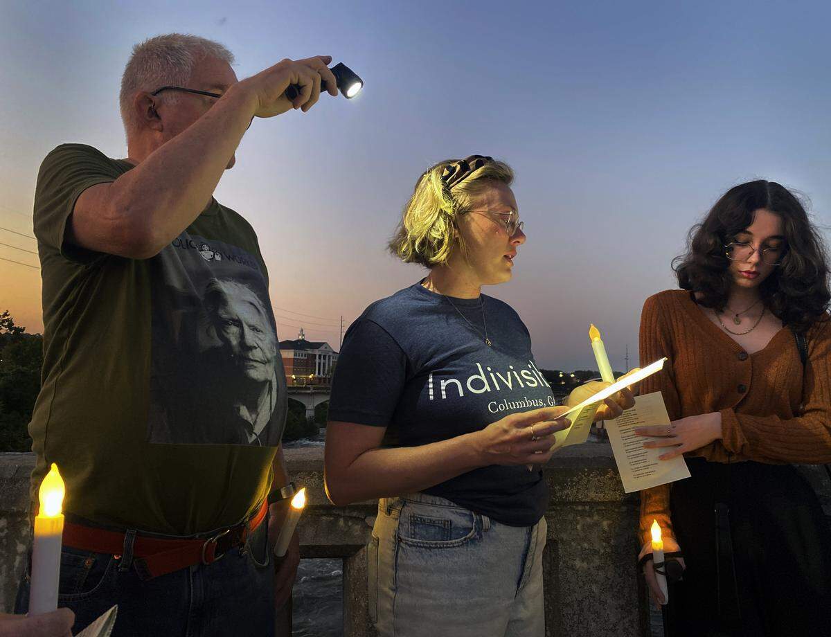 People gather Sept. 4, 2025, on the 13th Street Bridge, which connects Columbus, Georgia, to Phenix City, Alabama, for a candlelight vigil to remember and honor victims of gun violence. The event was organized by Phenix City Indivisible, Columbus, GA Indivisible and the Under the Muscadine Catholic Worker community.
