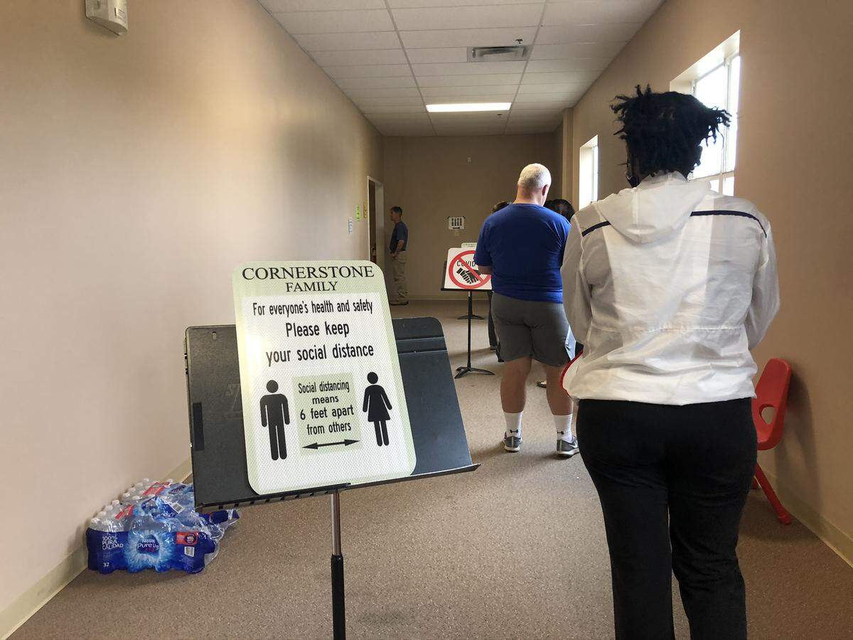 Voters at Cornerstone Church of God follow social distancing guidelines by standing six feet apart in line on June 9, 2020.