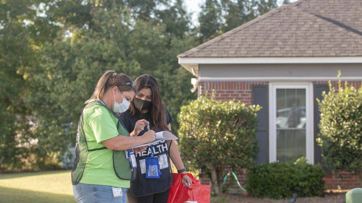 Health Department employees Nicole Morrison and Yashira Rojas find the next randomized house to survey on Sept. 28, 2021, in Columbus, Ga. A door-to-door survey was conducted in two zip codes with low vaccine rates to ask residents how they feel about the COVID-19 vaccine.