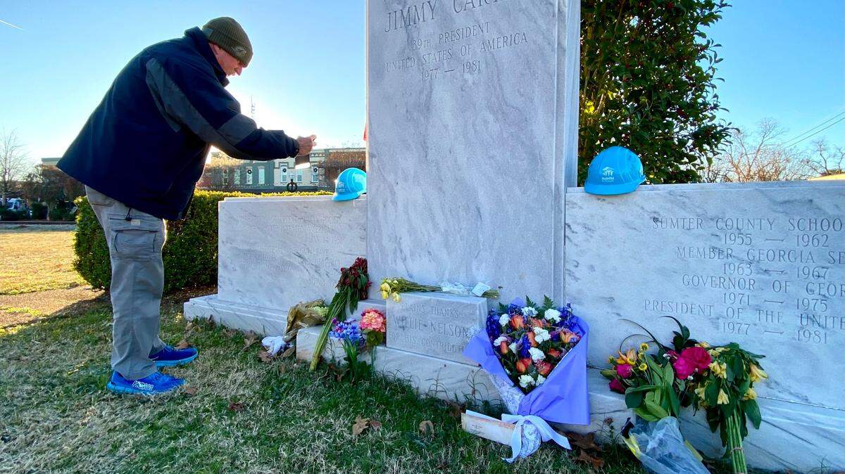 Jeff Robinson of Atlanta photographs a memorial display to Jimmy Carter located in downtown Plains, Ga.