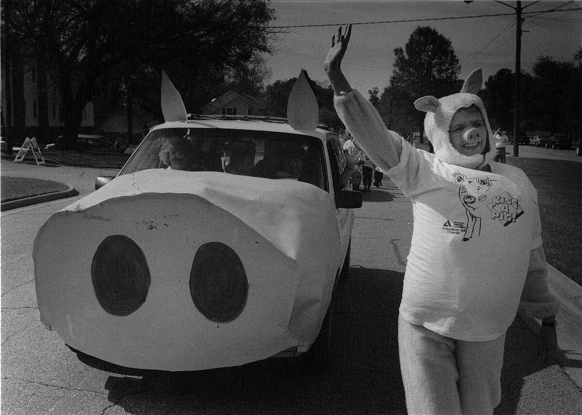 Brenda Story walks alongside a “pigmobile” during the “Hamit-up Parade” at Pig Jig.