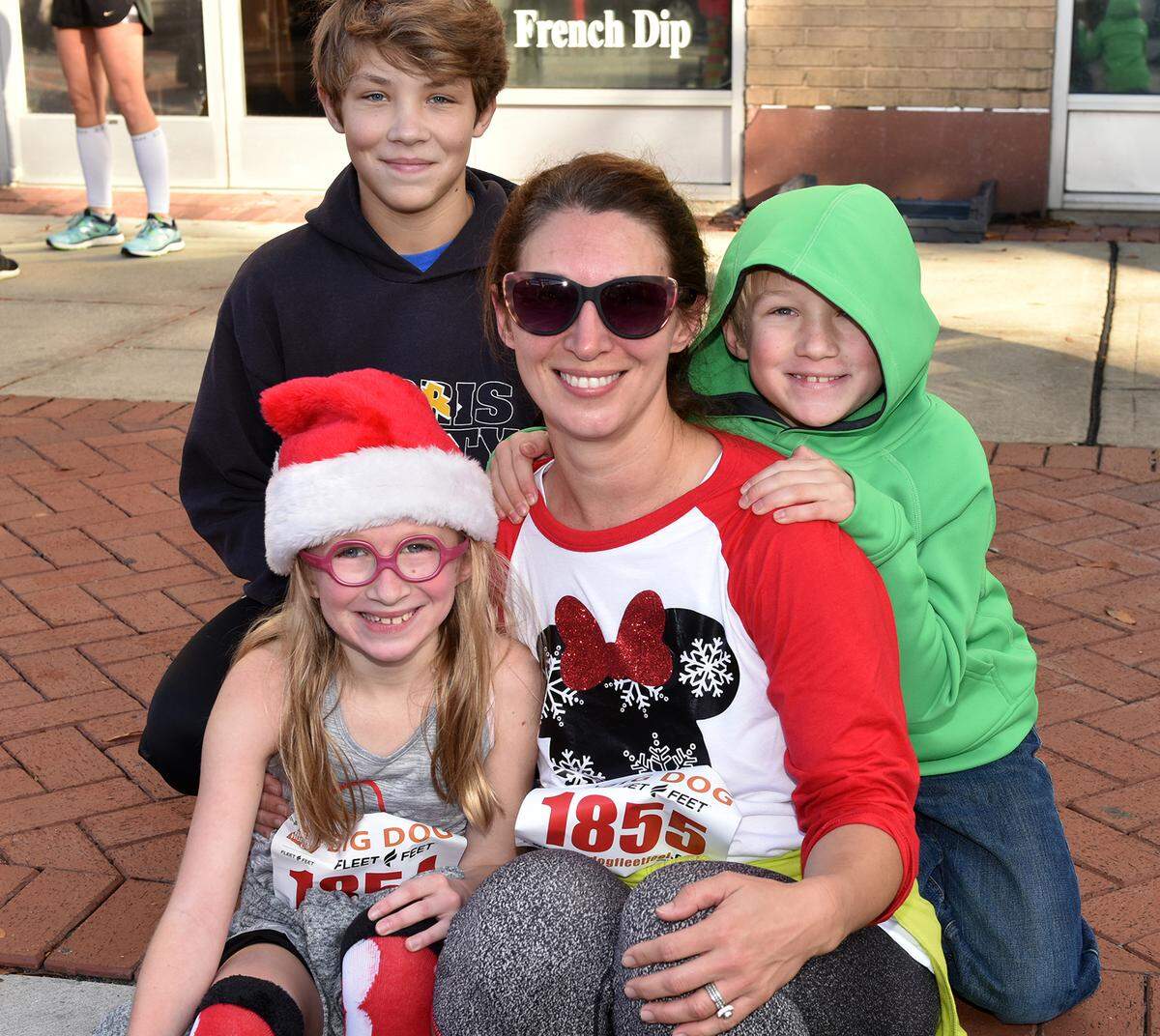 In this 2018 photo, Effie Ward, 10, finished the Big Dog Jingle 5K run with her mother Julie Ward, as her brothers Carson, left, and Cullen, right, cheered them across the finish line.
