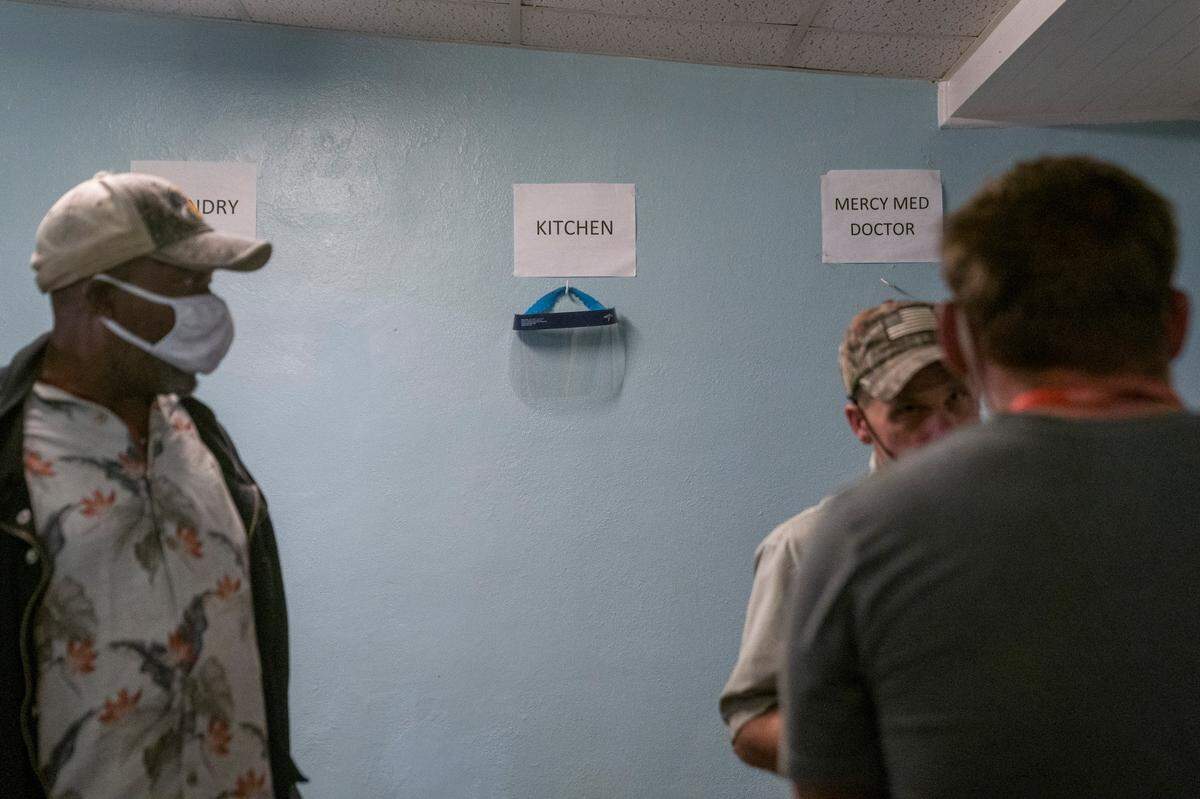 Staff encourage social distancing as a line forms to receive the COVID-19 vaccine on Thursday, April 8, 2021 at Safehouse Ministries in Columbus, Ga.