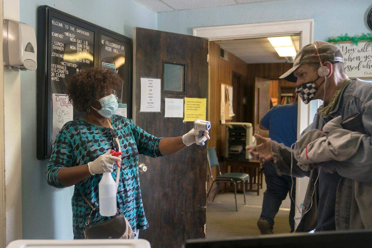 Volunteer Joanne Jones Crowley greets people at the door as they enter Safehouse on Thursday, April 8, 2021 at Safehouse in Columbus, Ga.