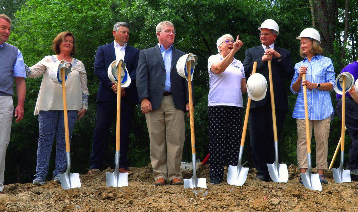 Cathy Williams, CEO of NeighborWorks Columbus (third from right), speaks to attendees during a 2022 grounbreaking ceremony for Elliott’s Walk, a 33-acre residential development in Columbus. It was considered the most extensive housing development for south Columbus in more than 50 years. comprising 43 single-family homes, 56 multifamily homes and 130 units available for older citizens.