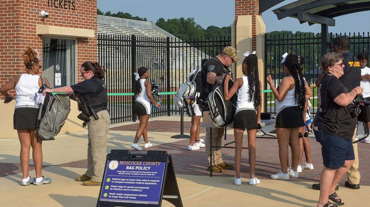 Muscogee County School District police officers check bags of guest entering the Odis Spencer Stadium for the Kendrick versus Shaw high school football game Aug. 24, 2023., in Columbus.